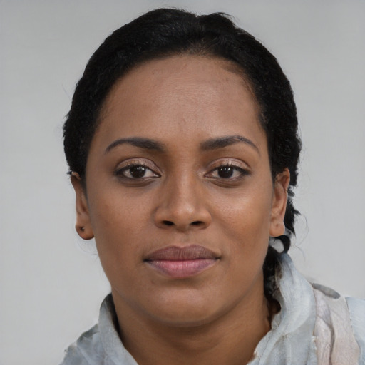 Joyful black young-adult female with short  black hair and brown eyes