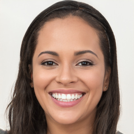 Joyful latino young-adult female with long  brown hair and brown eyes