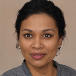 Joyful black adult female with medium  brown hair and brown eyes