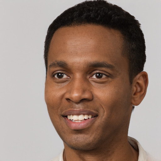 Joyful black young-adult male with short  black hair and brown eyes
