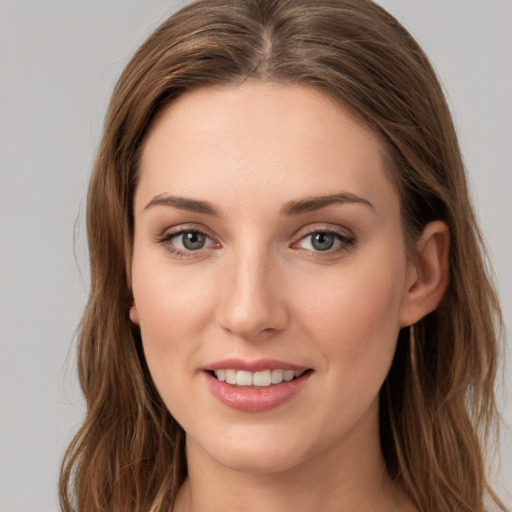 Joyful white young-adult female with long  brown hair and green eyes