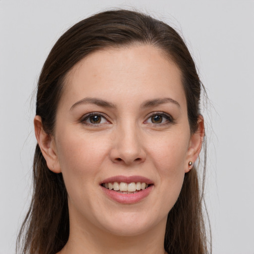 Joyful white young-adult female with long  brown hair and grey eyes