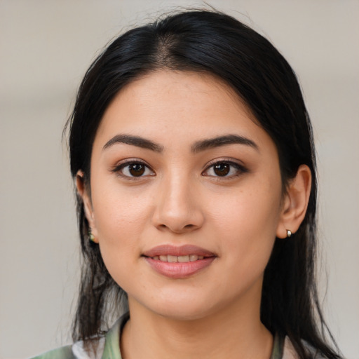 Joyful latino young-adult female with long  black hair and brown eyes