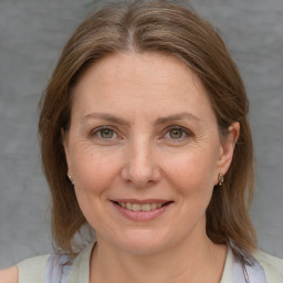 Joyful white adult female with medium  brown hair and blue eyes