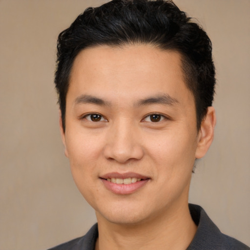 Joyful asian young-adult male with short  black hair and brown eyes