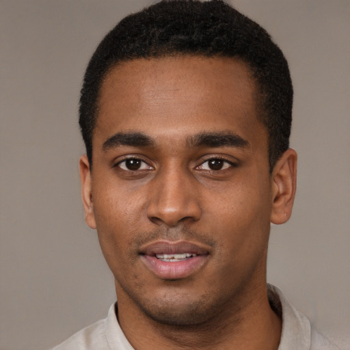 Joyful black young-adult male with short  black hair and brown eyes