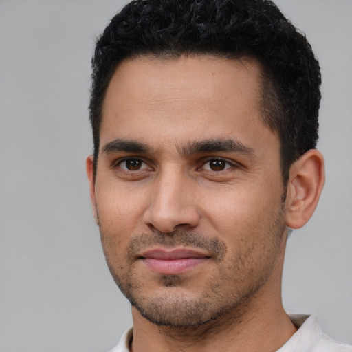 Joyful white young-adult male with short  black hair and brown eyes