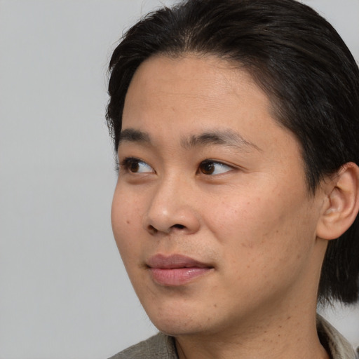 Joyful asian young-adult male with medium  black hair and brown eyes
