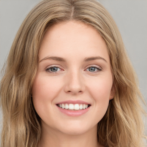 Joyful white young-adult female with long  brown hair and green eyes