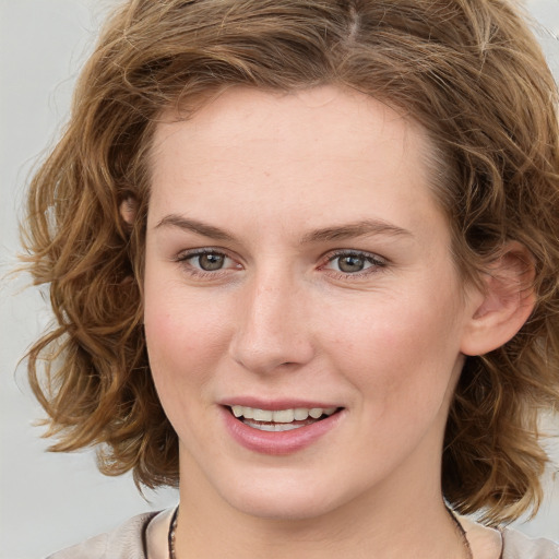 Joyful white young-adult female with medium  brown hair and blue eyes