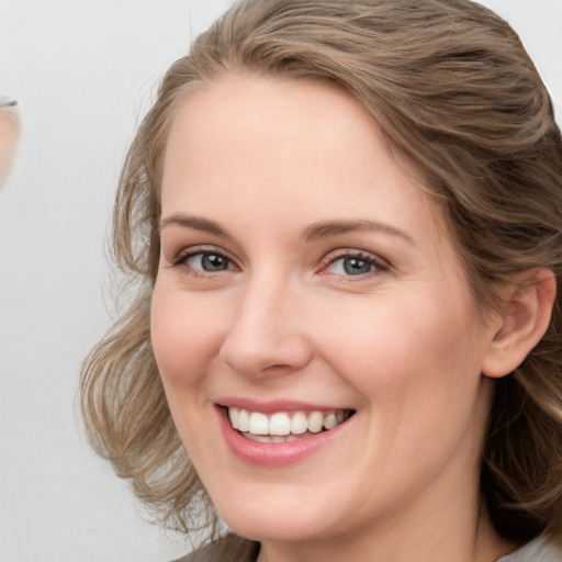 Joyful white young-adult female with medium  brown hair and blue eyes