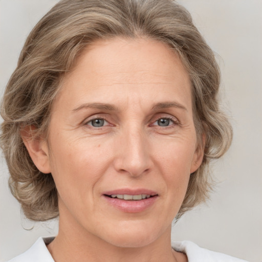 Joyful white adult female with medium  brown hair and grey eyes