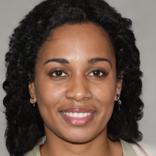 Joyful black young-adult female with long  black hair and brown eyes