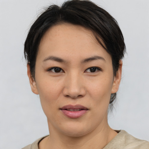 Joyful asian young-adult female with short  brown hair and brown eyes