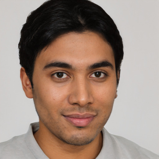 Joyful latino young-adult male with short  black hair and brown eyes