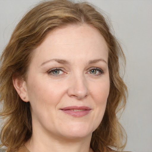 Joyful white adult female with medium  brown hair and blue eyes