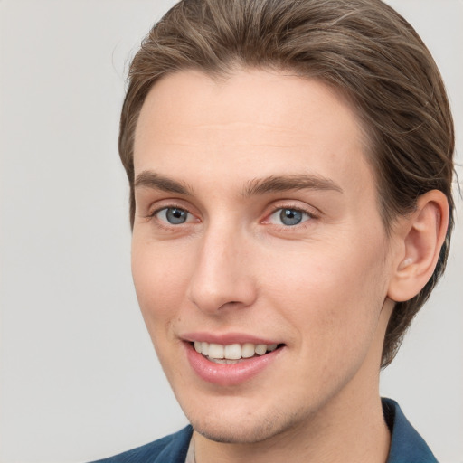 Joyful white young-adult male with short  brown hair and grey eyes