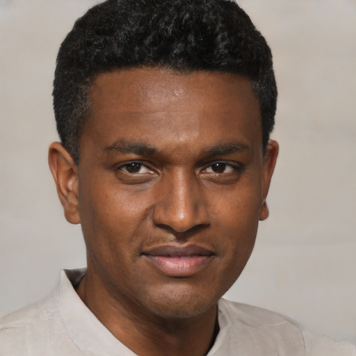 Joyful black young-adult male with short  black hair and brown eyes