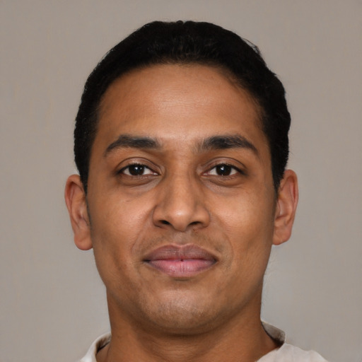 Joyful latino young-adult male with short  black hair and brown eyes