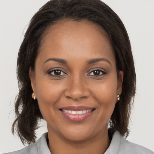 Joyful black young-adult female with medium  brown hair and brown eyes