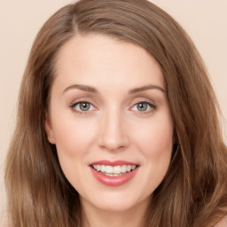 Joyful white young-adult female with long  brown hair and blue eyes