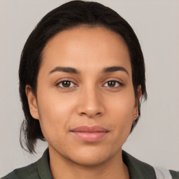 Joyful latino young-adult female with medium  brown hair and brown eyes