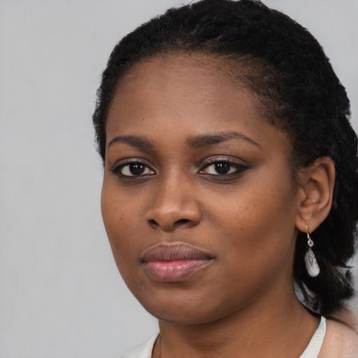 Joyful black young-adult female with short  black hair and brown eyes