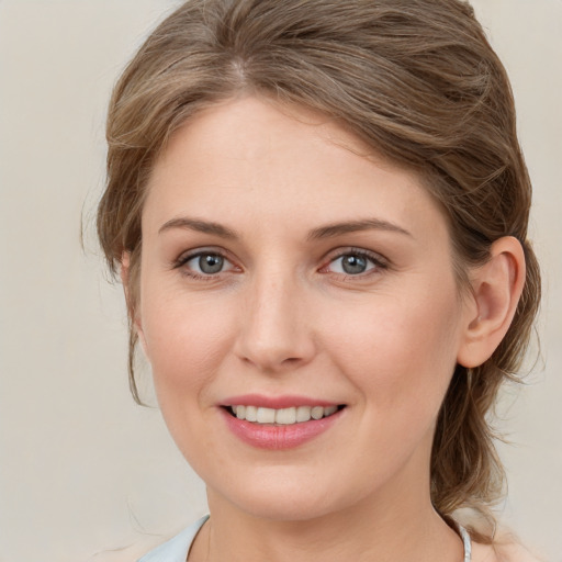 Joyful white young-adult female with medium  brown hair and grey eyes