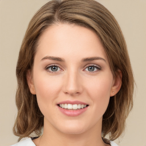 Joyful white young-adult female with medium  brown hair and green eyes