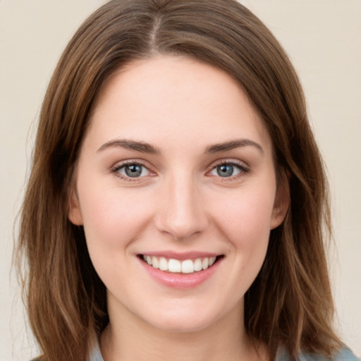 Joyful white young-adult female with medium  brown hair and green eyes