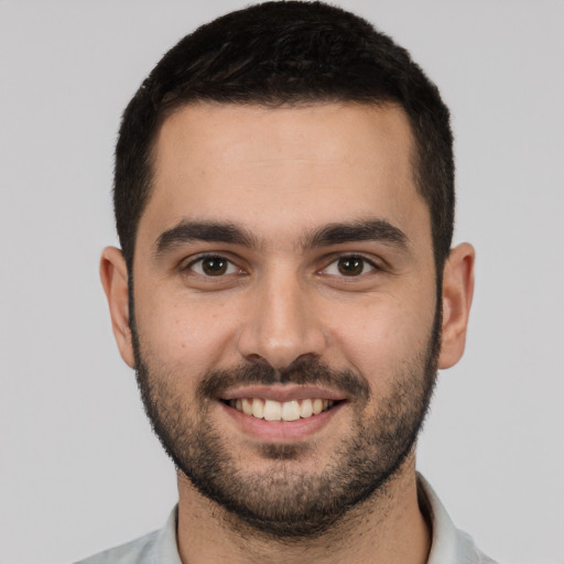 Joyful white young-adult male with short  black hair and brown eyes