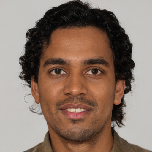 Joyful black young-adult male with short  brown hair and brown eyes