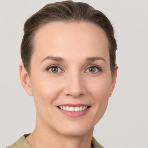 Joyful white young-adult female with short  brown hair and grey eyes