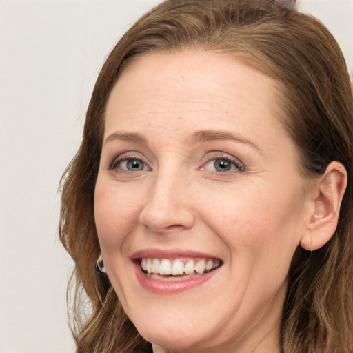 Joyful white adult female with long  brown hair and blue eyes