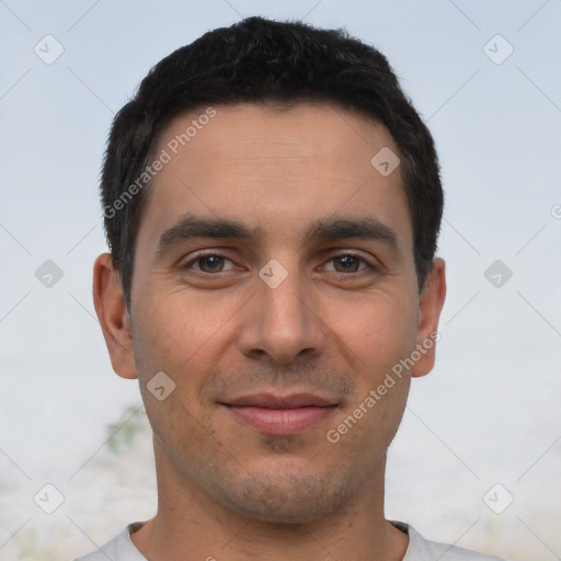 Joyful white young-adult male with short  black hair and brown eyes