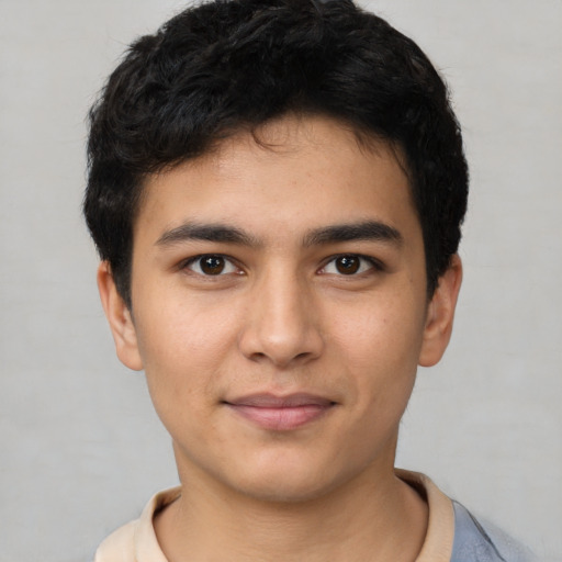 Joyful latino young-adult male with short  brown hair and brown eyes