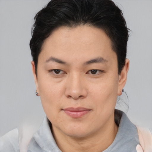 Joyful asian adult female with short  brown hair and brown eyes