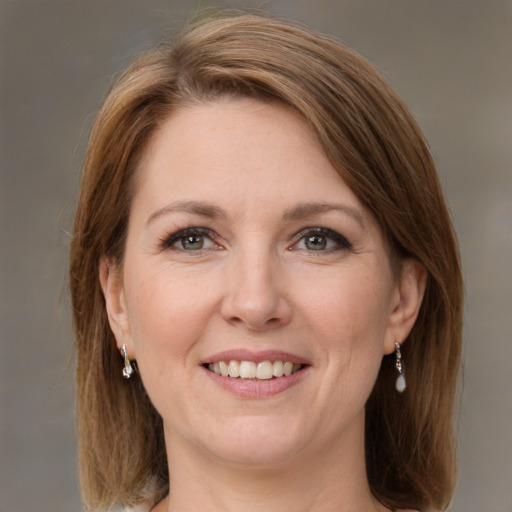 Joyful white adult female with medium  brown hair and grey eyes