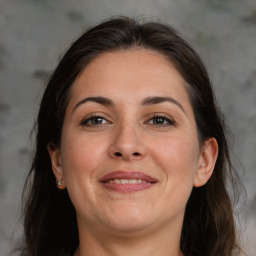 Joyful white adult female with long  brown hair and brown eyes