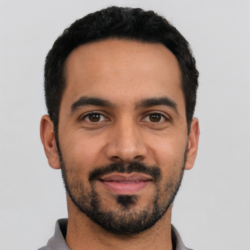 Joyful latino young-adult male with short  black hair and brown eyes
