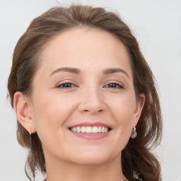 Joyful white young-adult female with medium  brown hair and grey eyes