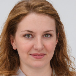 Joyful white young-adult female with long  brown hair and green eyes