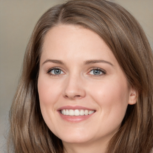 Joyful white young-adult female with long  brown hair and grey eyes