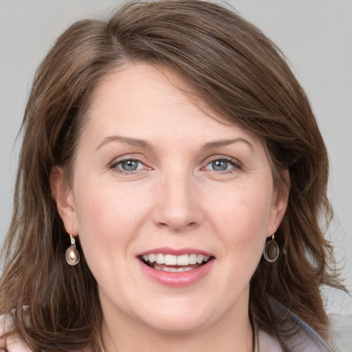 Joyful white adult female with medium  brown hair and grey eyes