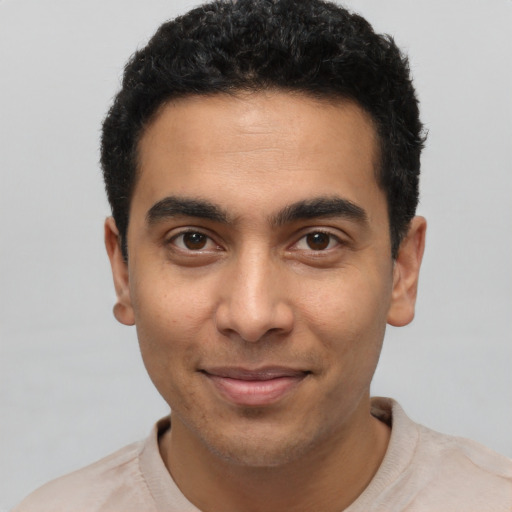 Joyful latino young-adult male with short  black hair and brown eyes