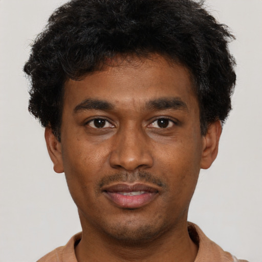 Joyful black young-adult male with short  black hair and brown eyes