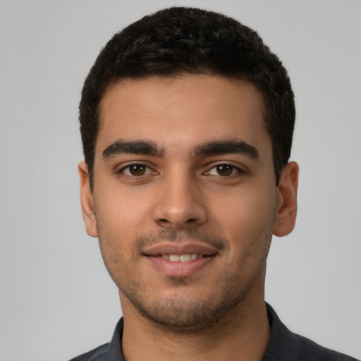 Joyful latino young-adult male with short  black hair and brown eyes