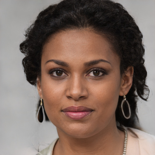 Joyful black young-adult female with medium  brown hair and brown eyes