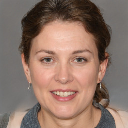 Joyful white adult female with medium  brown hair and blue eyes