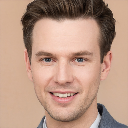 Joyful white young-adult male with short  brown hair and grey eyes